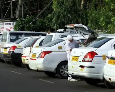 Driver in uniform loading luggage into a white cab